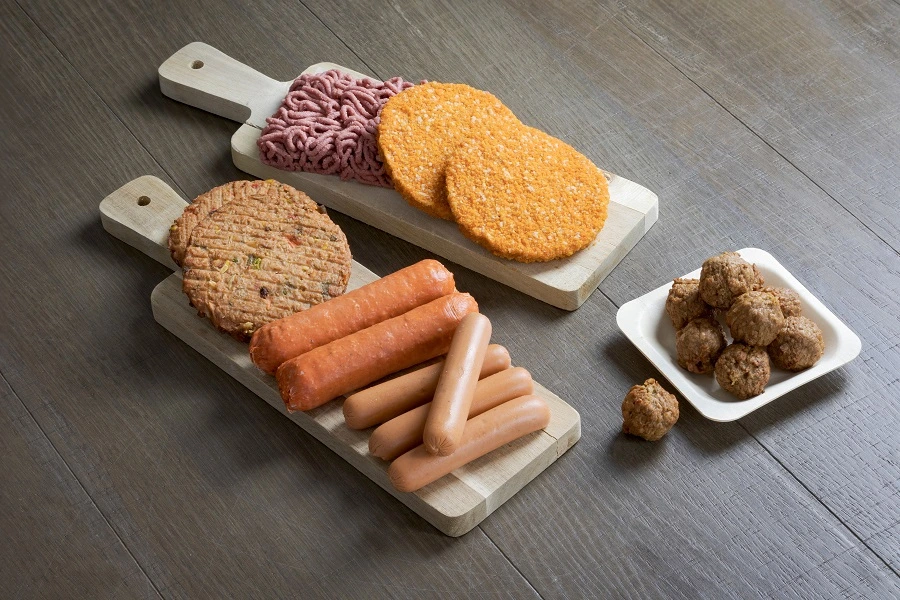 plant based protein patty, sausage and balls on a brown table